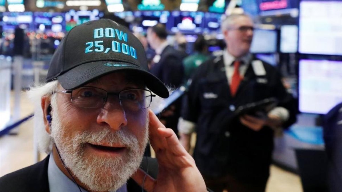 Un operador de Wall Street luce una gorra conmemorativa de los 25.000 puntos alcanzados por el Dow Jones.-LUCAS JACKSON