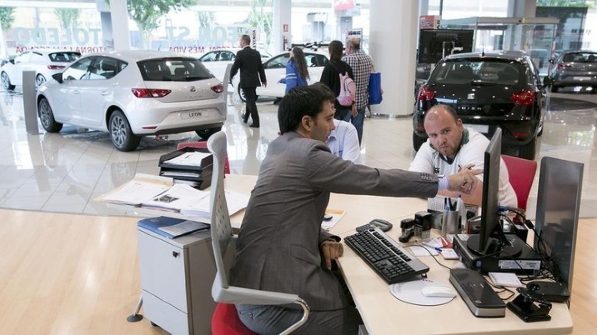 Un cliente de un concesionario de coches pide información.-