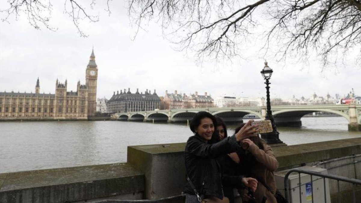 Turistas haciéndose un selfi frente al Parlamento de Westminster.-AFP / ADRIAN DENNIS