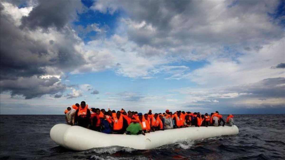 Una balsa con inmigrantes a la deriva en el Mar Mediterráneo a unas 36 millas náuticas de la costa libia antes de ser rescatados por la ONG Proactiva Open Arms.-REUTERS / YANNIS BEHRAKIS