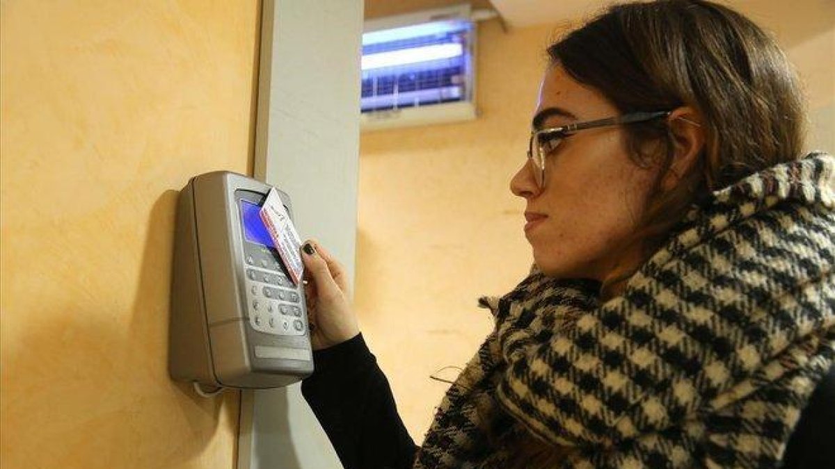 Una empleada ficha a la entrada de su trabajo.-ELISENDA PONS