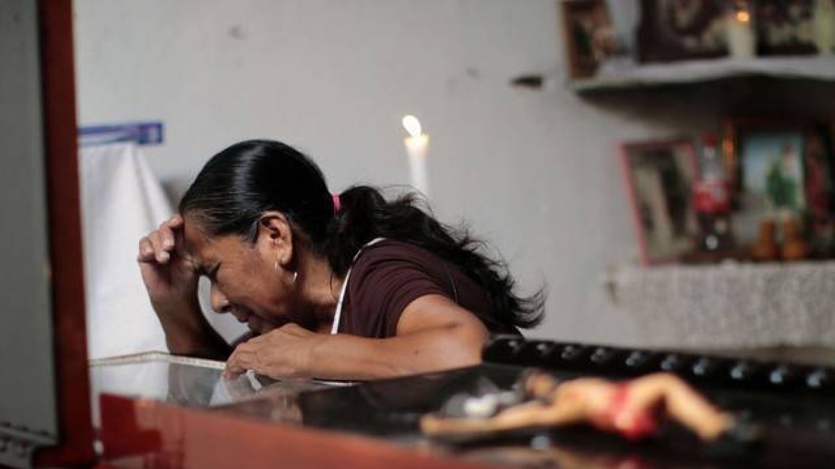 Una mujer llora sobre el féretro de Miguel Ángel Jiménez, este domingo en Xaltianguis.-AFP