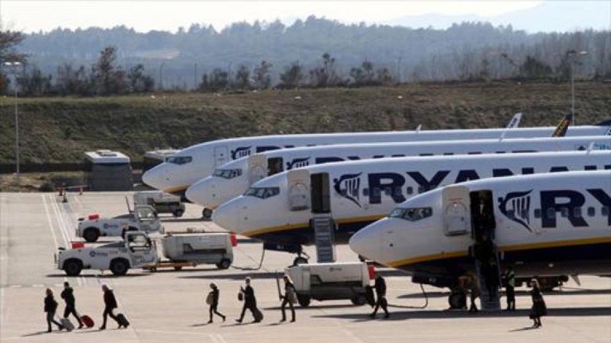 Pasajeros de Ryanair desembarcan de uno de los aparatos de la compañía en el aeropuerto de Girona.-/ CLICK ART FOTO / JOAN CASTRO