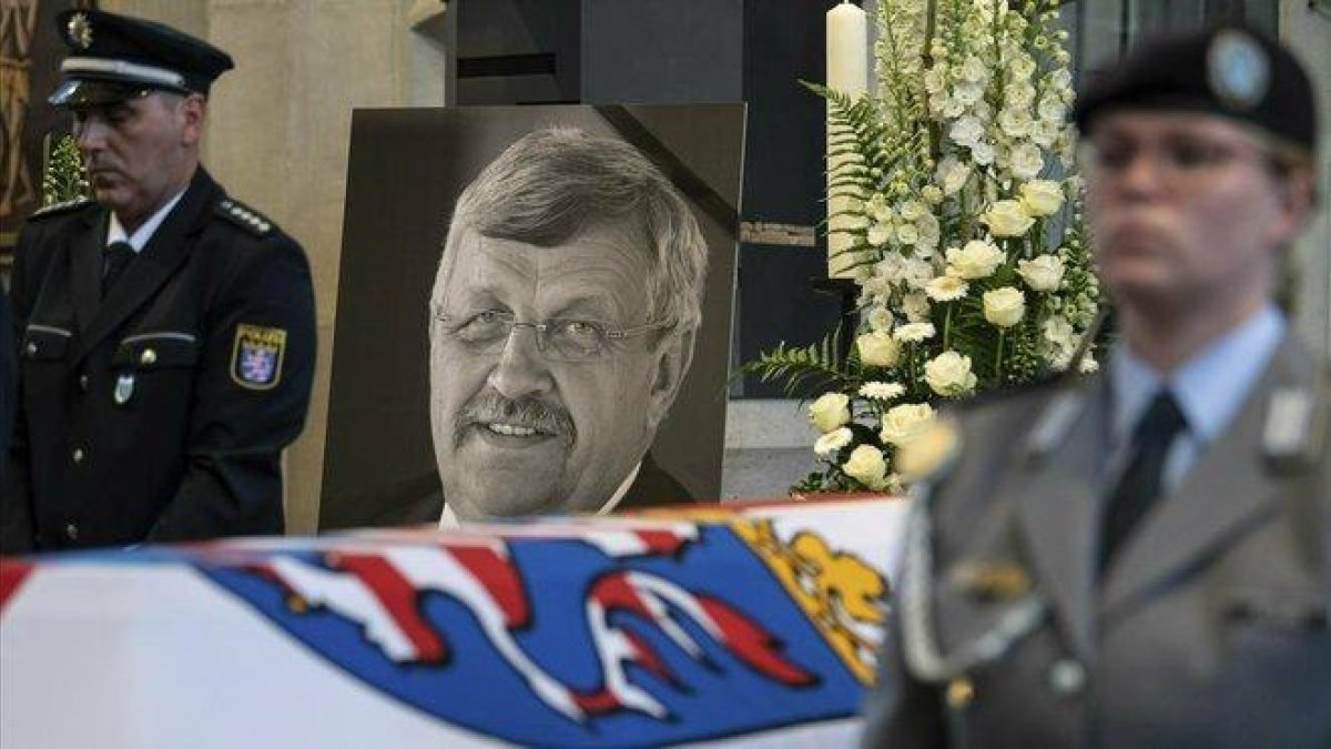 Un guarda de honor junto a la foto del político alemán asesinado Walter Lübcke durante el funeral en la iglesia de St. Martin en Kassel.-AP