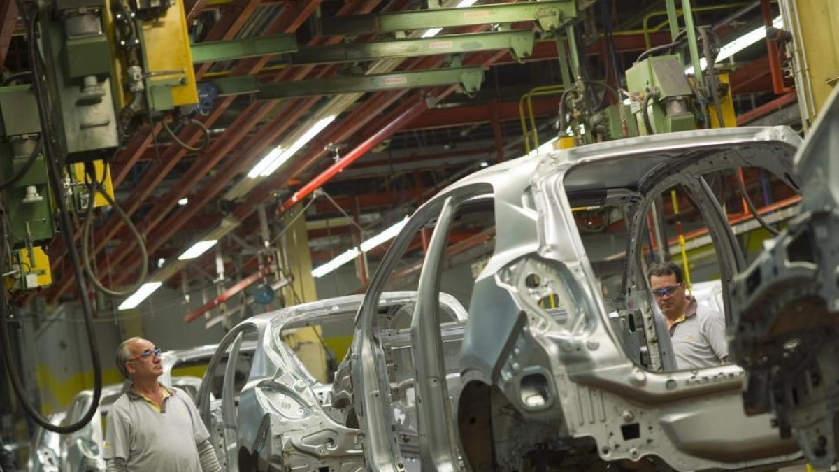 Dos operarios en una imagen de archivo en la fábrica de General Motors España en Figueruelas (Zaragoza)-TONI GALÁN (EFE)