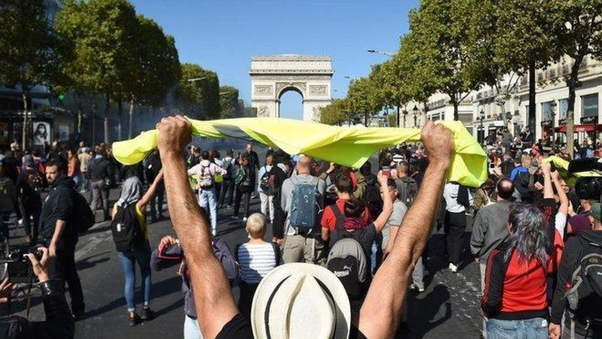 Chalecos amarillos en los Campos Elíseos, ante el Arco de Triunfo.-AFP / LUCAS BARIOULET