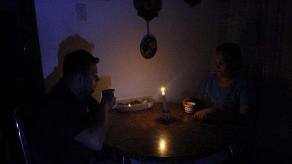 Una pareja toma un café en una establecimiento público a la luz de las velas.-EFE
