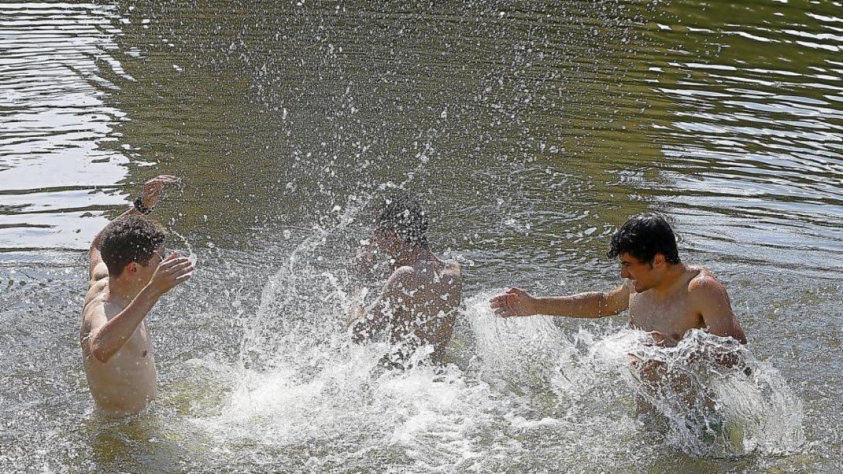 Jóvenes refrescándose durante la ola de calor en la Playa de las Moreras de Valladolid-J. M. LOSTAU