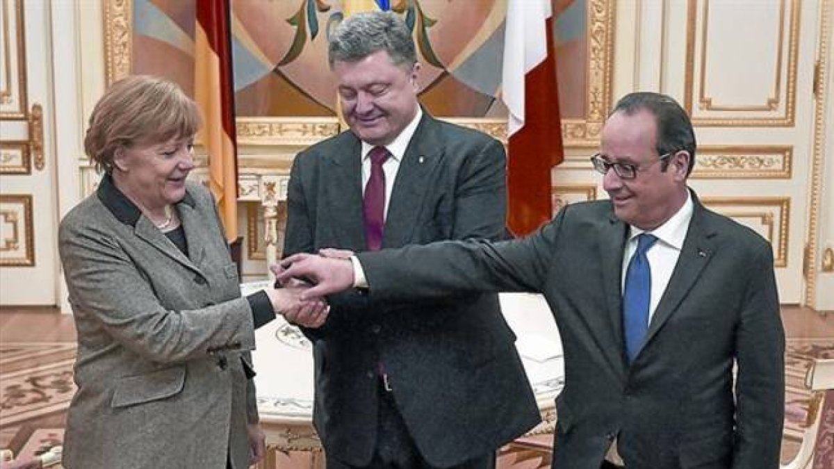 Merkel y Hollande, con el presidente ucraniano, Petró Poroshenko (en el centro), justo antes del inicio de la reunión, ayer, en Kiev.-Foto: REUTERS