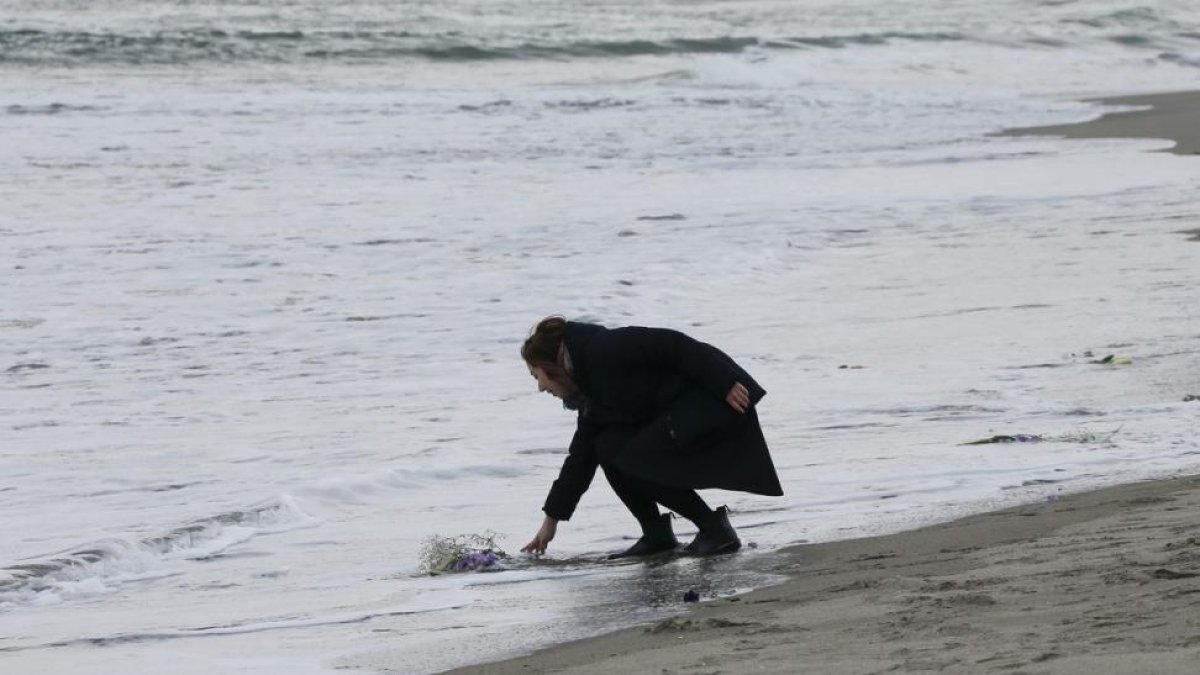 Mark Kanekita, de 37 años, lanza flores al mar en memoria de las víctimas del terremoto y posterior tsunami de hace cinco años en el distrito de Abraham en Sendai (Japón).-KIMIMASA MAYAMA / EFE