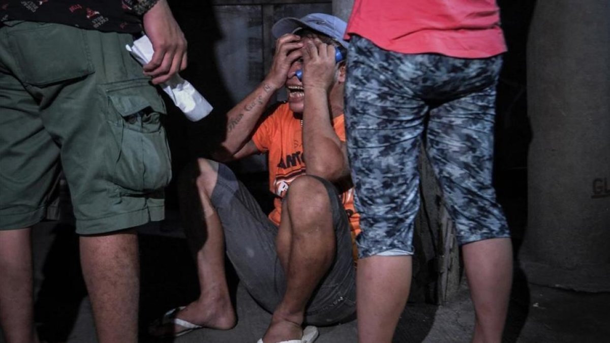 Un familiar llora a una víctima de una operración policial antidroga en Manila, el 17 de agosto.-EFE / EZRA ACAYAN
