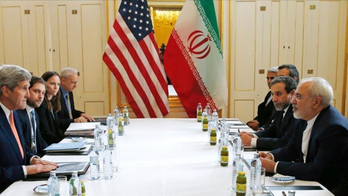 La delegación de EEUU, presidida por el secretario de Estado, John Kerry, con la delegación iraní liderada por su homólogo Javad Zarif, el 16 de enero del 2016.-AFP / KEVIN LAMARQUE