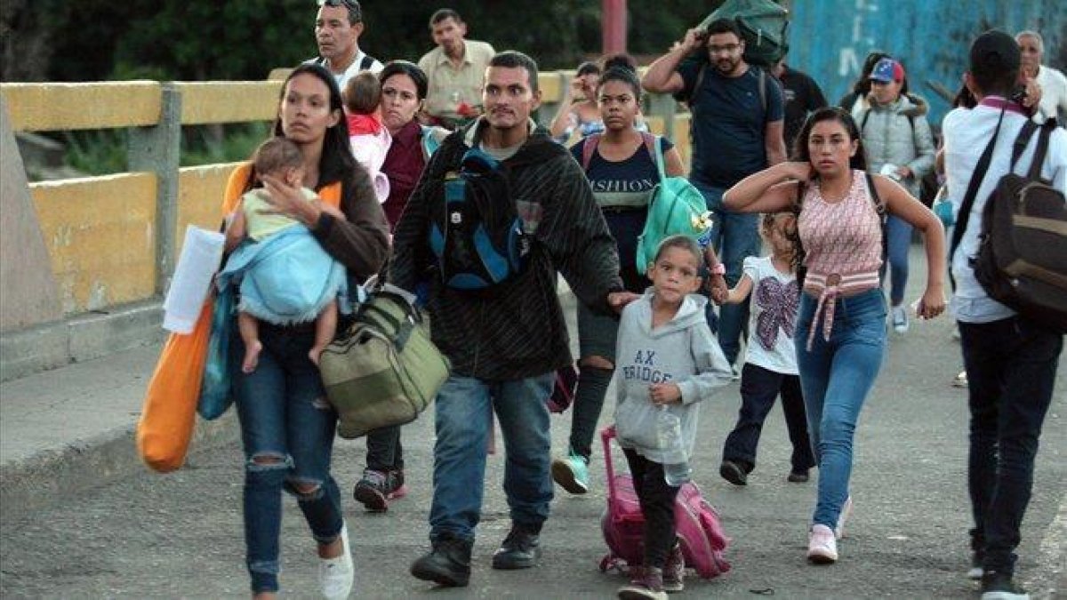 Una familia de inmigrantes venezolana pasa hacia Colombia por el Puente Internacional Simon Bolivar.-EFE