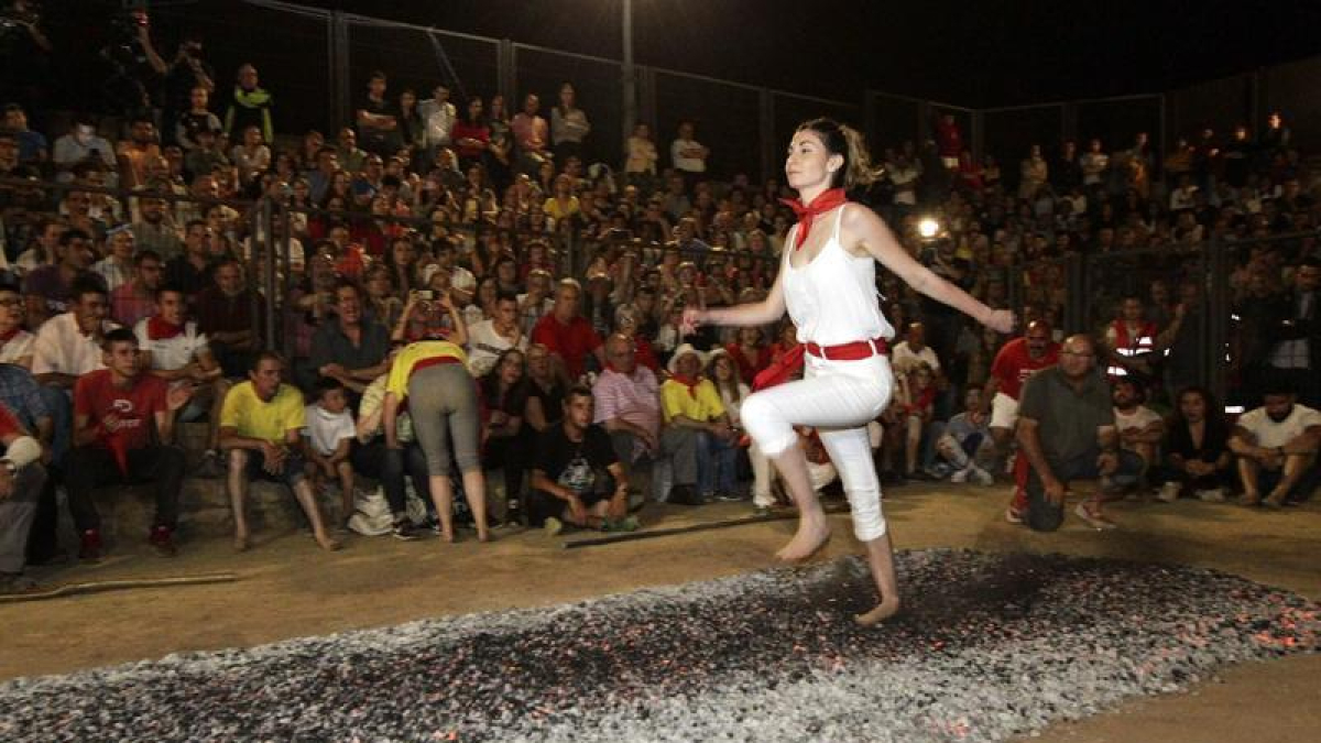 Joven cruzando la alfombra de brasas en San Pedro Manrique.-HDS