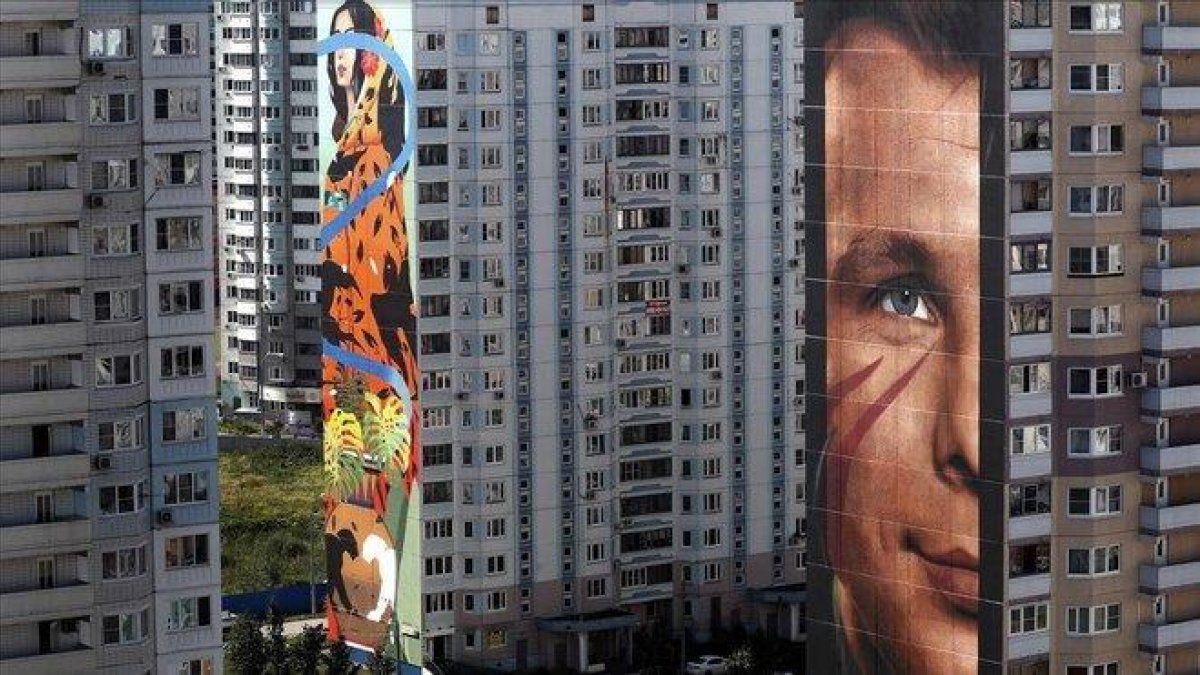 En primer plano, el retrato del cosmonauta Yuri Gagarin obra del italiano Jorit Agoch, en Odintsovo.-EFE / MAXIM SHIPENKOV