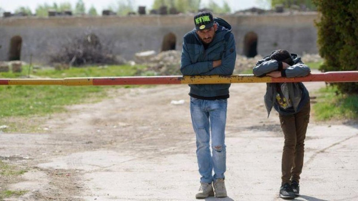 Dos regugiados en Subotica, en territorio serbio, a unos 10 kilometros de la frontera con Hungría.-EFE / EDVARD MOLNAR