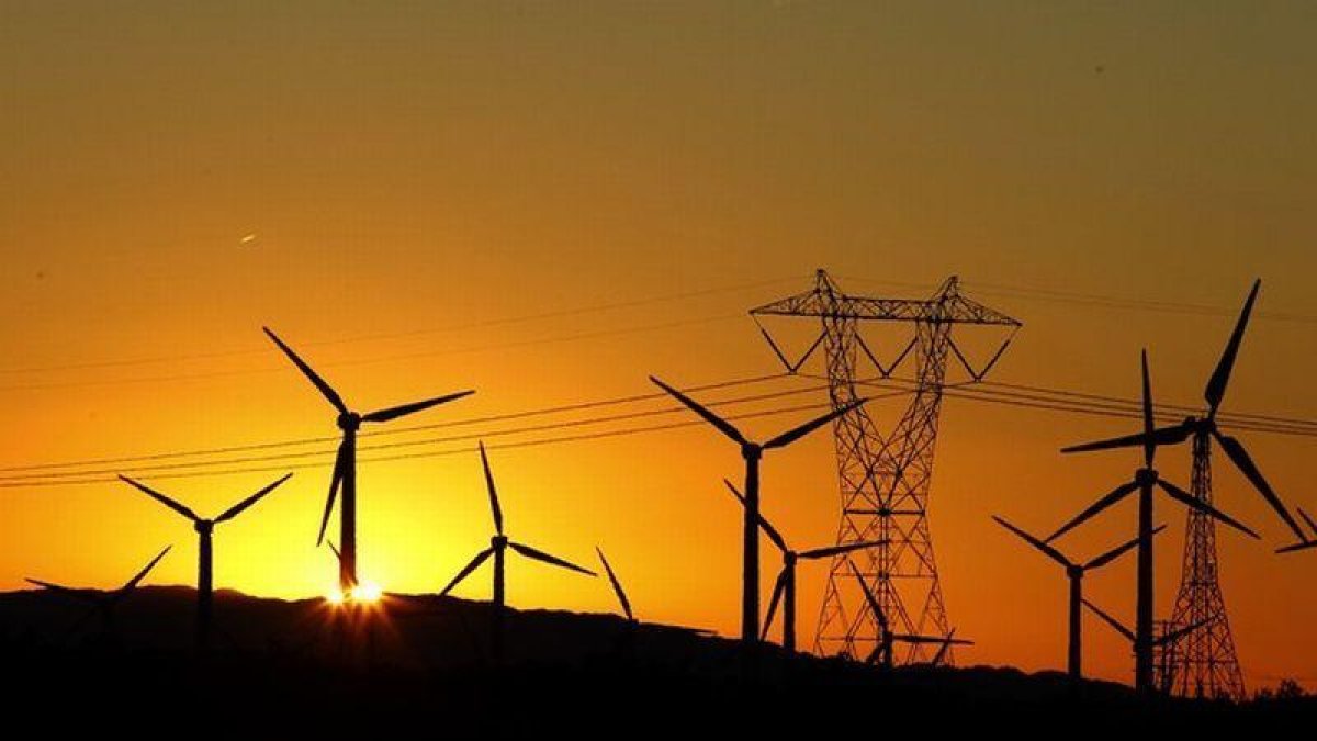 Torre eléctrica y molinos de energía eólica.-LUCY NICHOLSON (REUTERS)