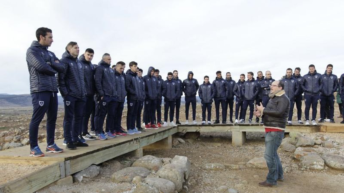 La plantilla y el cuerpo técnico rojillo recorrieron el yacimiento de Numancia en una visita guiada de la mano del arqueólogo Antonio Chaín.-Luis Ángel Tejedor