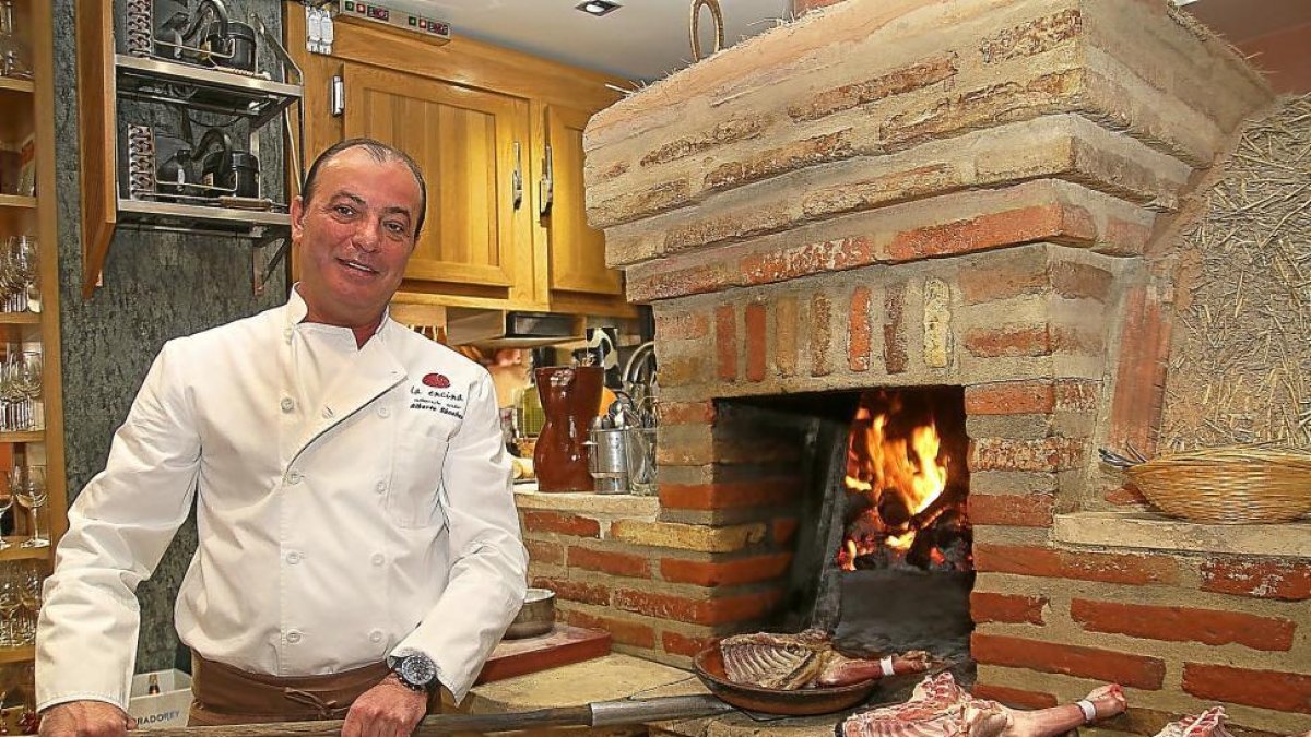 Alberto Sánchez, propietario del restaurante La Encina, se dispone a asar unos cuartos de lechazo.-BRÁGIMO