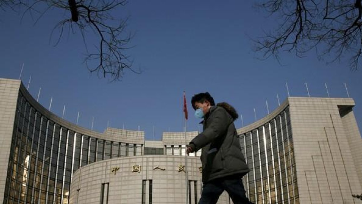 Un hombre pasa por delante de la sede del Banco Central de China, este martes en Pekín.-REUTERS / KIM KYUNG-HOON