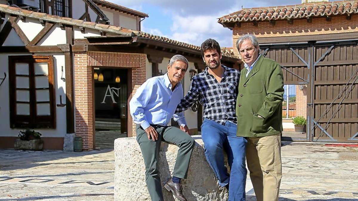 Los hermanos José Luis (i) y Javier (d) Ruiz Madroño posan con Luis Miguel Pérez en el patio de Bodegas Mocén, en Rueda (Valladolid).-M.T.