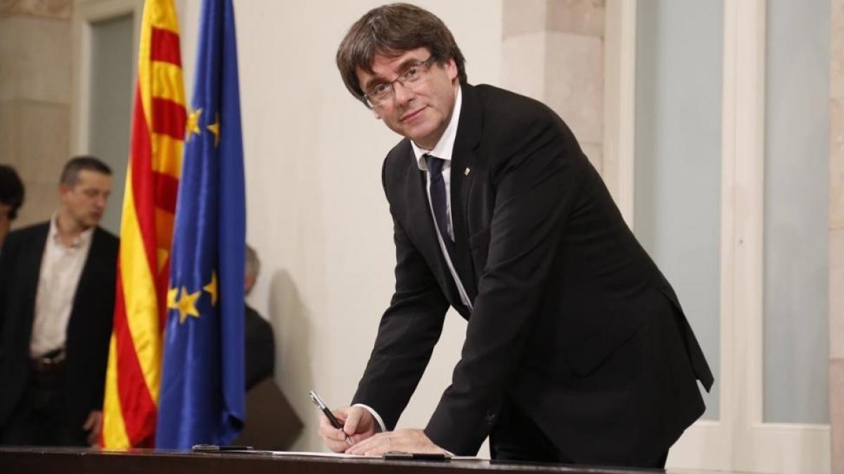 El president Carles Puigdemont en el momento de firmar la declaración, tras el pleno.-JULIO CARBÓ