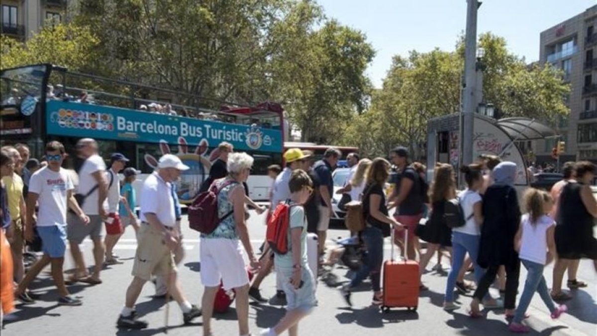 Turistas en la plaza de Catalunya de Barcelona.-JORDI COTRINA