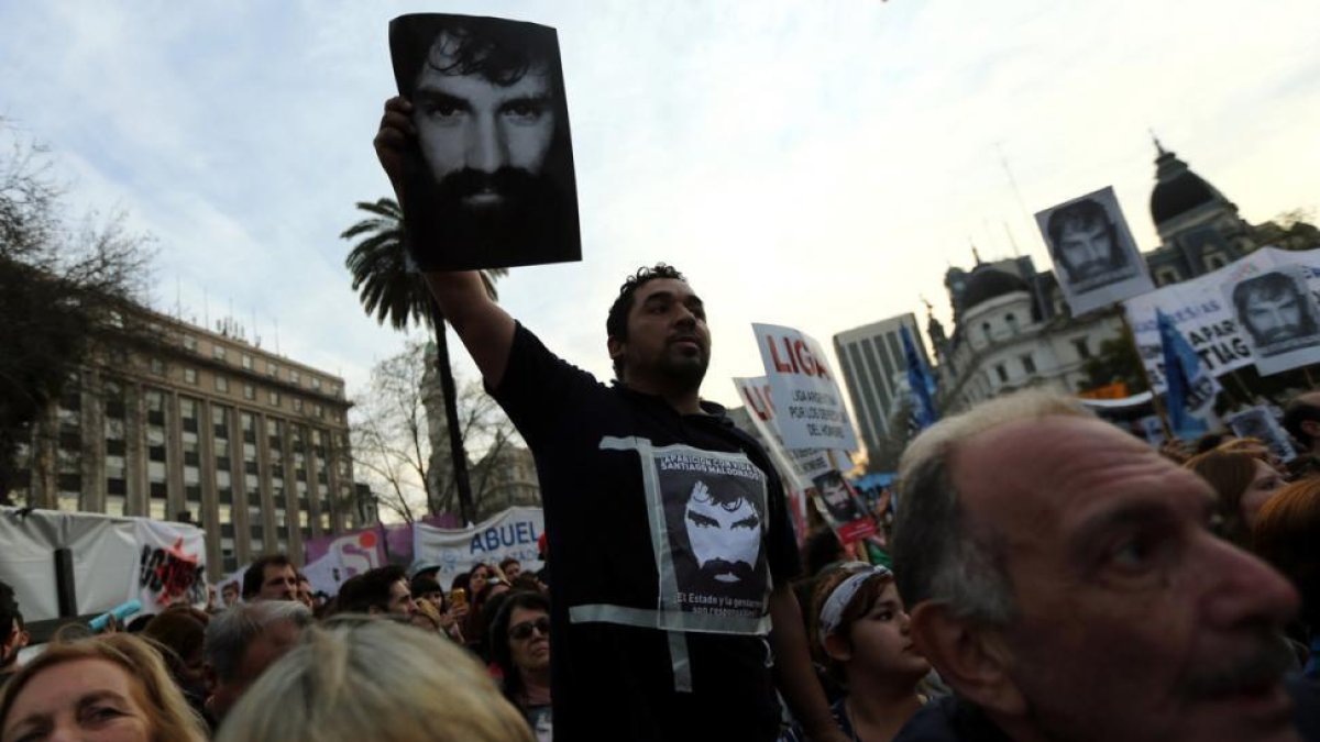 Un manifestante sostiene la foto de Santiago Maldonado, manifestante desaparecido durante unas protestas de apoyo a los indios mapuches.-MARCOS BRINDICCI (REUTERS)