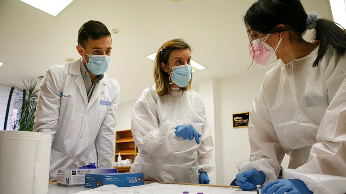 Profesionales sanitarios con viales de suero de la vacuna. HDS