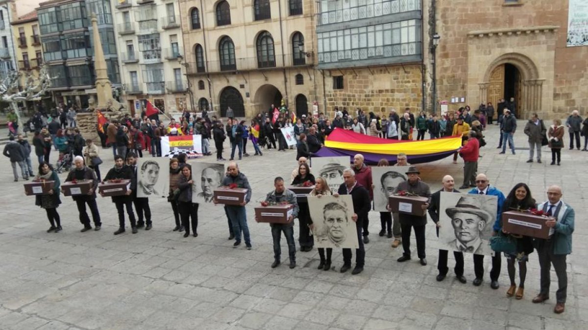 Los familiares de los asesinados con sus restos y retratos en la plaza Mayor.-TOÑO CARRILLO