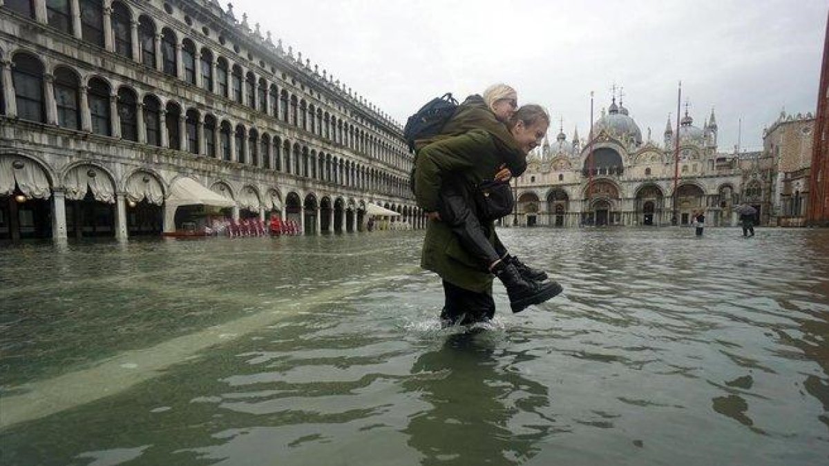 Una pareja cruza la plaza San Marcos.-EFE /EPA ANDREA MEROLA