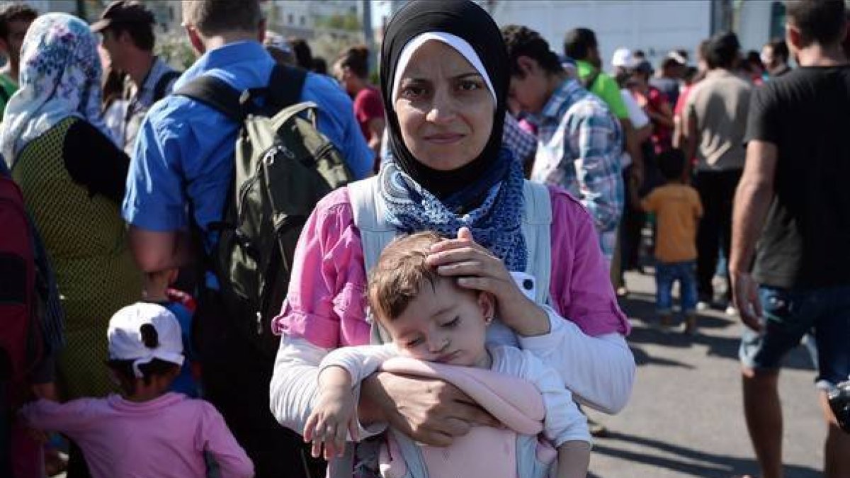 Una refugiada siria con su hija tras llegar a Grecia.-AFP / LOUISA GOULIAMAKI