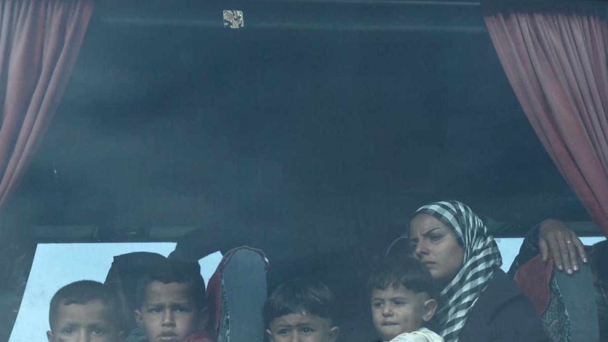 Una mujer y sus hijos, a bordo del autobús que les ha sacado del campo de Idomeni, esta mañana.-AP