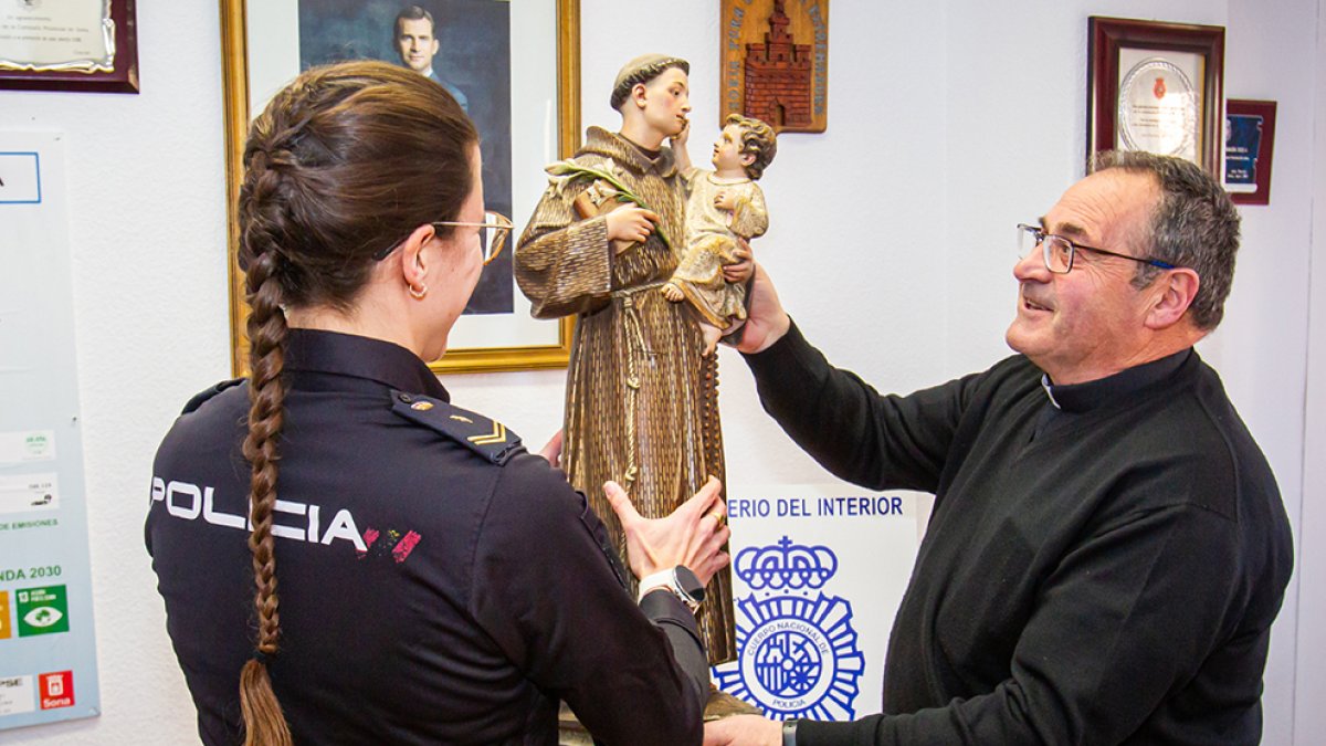 El párroco del Espino recibe la talla de manos de una policía. MARIO TEJEDOR