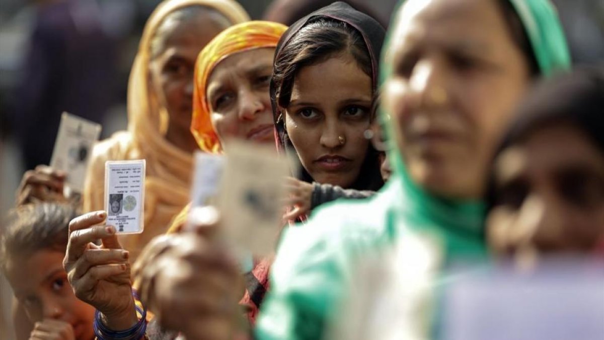 Varias mujeres hacen cola en un colegio electoral durante la segunda fase de las elecciones para la Asamblea estatal de Gujarat, en Ahmedabad (India), el 14 de diciembre.-EFE