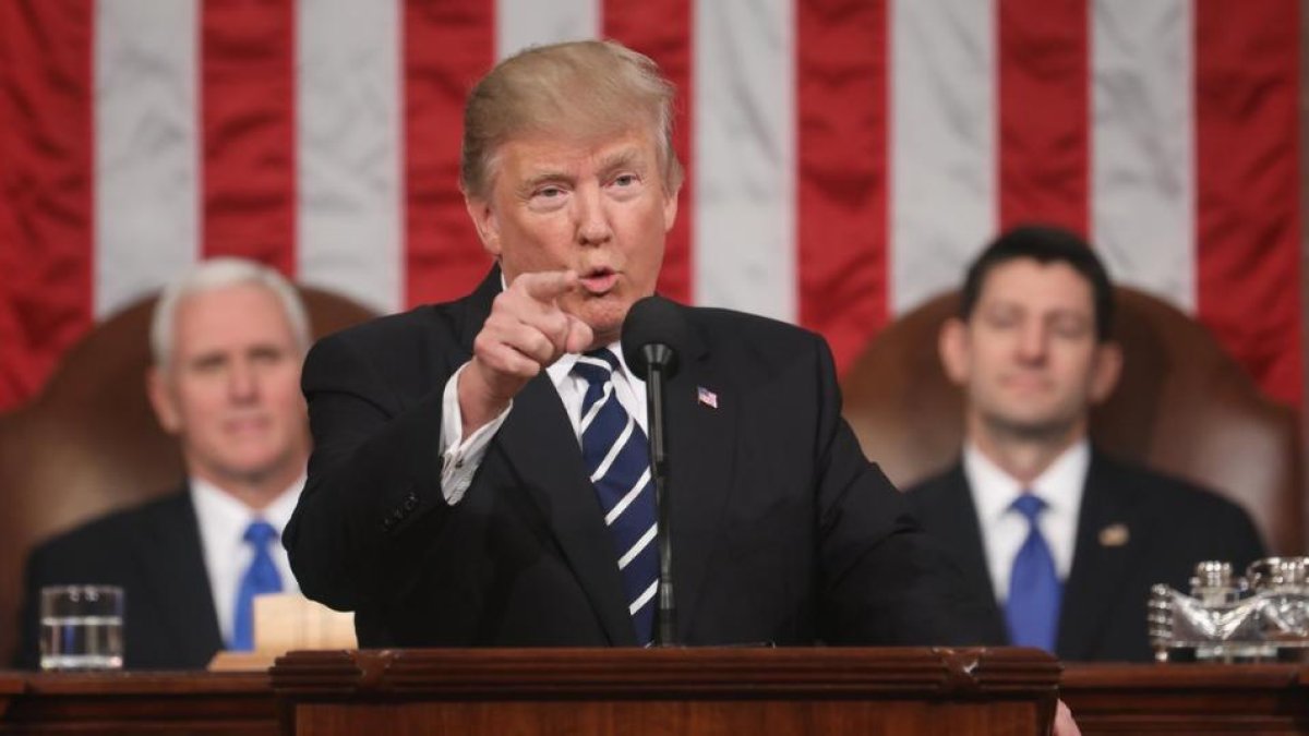 Trump, observado por el vicepresidente Pence (izquierda) y  por Paul Ryan, durante su discurso al Congreso.-JIM LO SCALZO