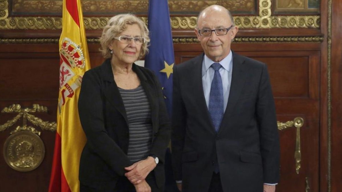 La alcaldesa de Madrid, Manuela Carmena, y el ministro de Hacienda, Cristobal Montoro, tras reunirse en noviembre del 2016.-EFE