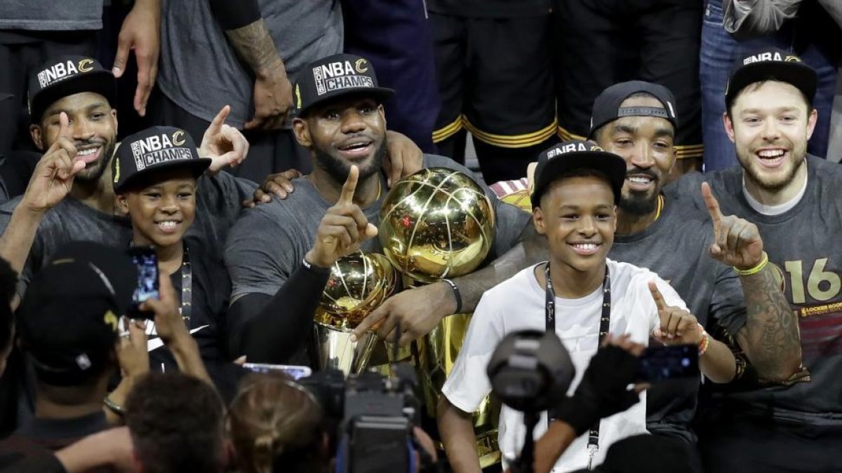 LeBron James celebra con sus dos hijos la victoria de Cleveland en la NBA.-AFP