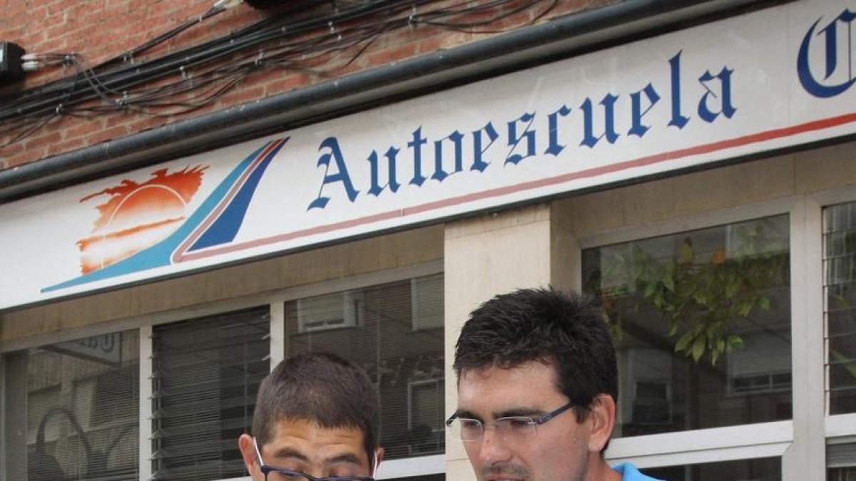 Dos alumnos de autoescuela con el manual.-BRÁGIMO-ICAL