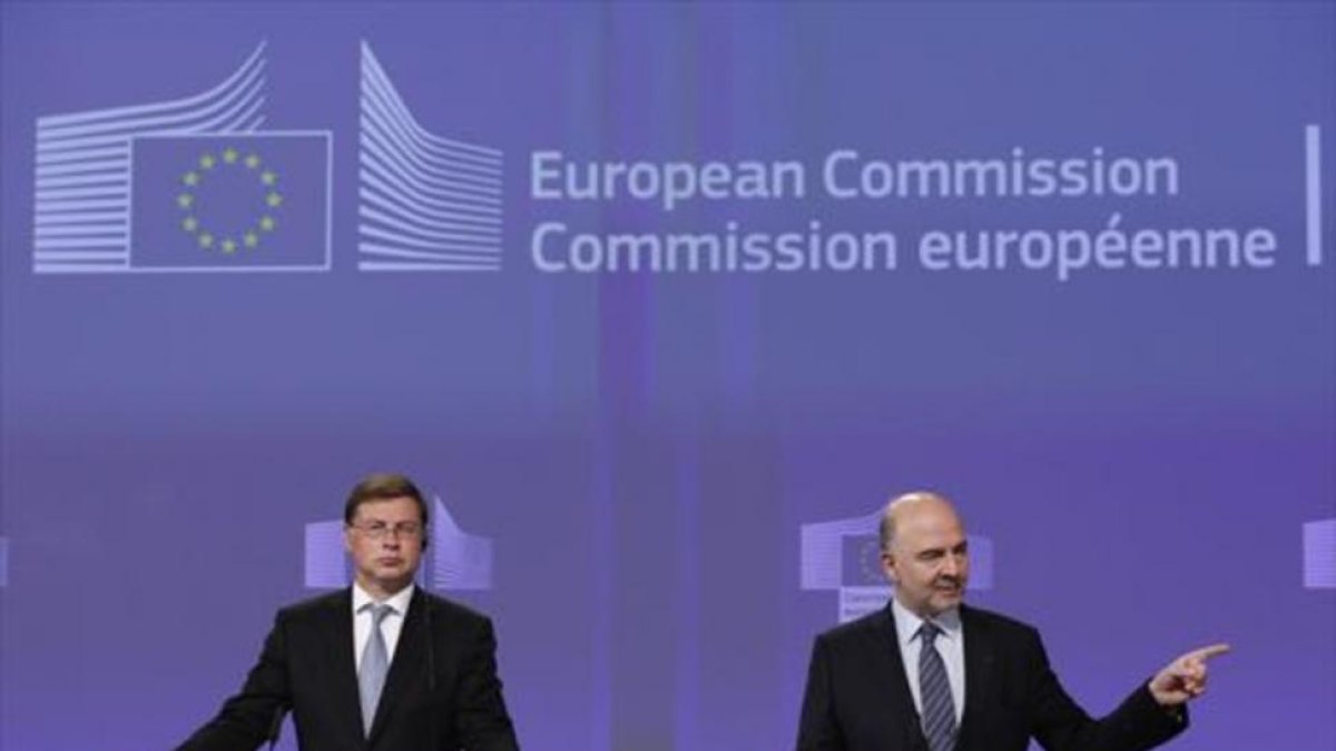 El comisario Moscovici (derecha), y el vicepresidente Dombrovskis, en la rueda de prensa en la que justificaron la cancelación de la multa a España.-EFE / LAURENT DUBRULE