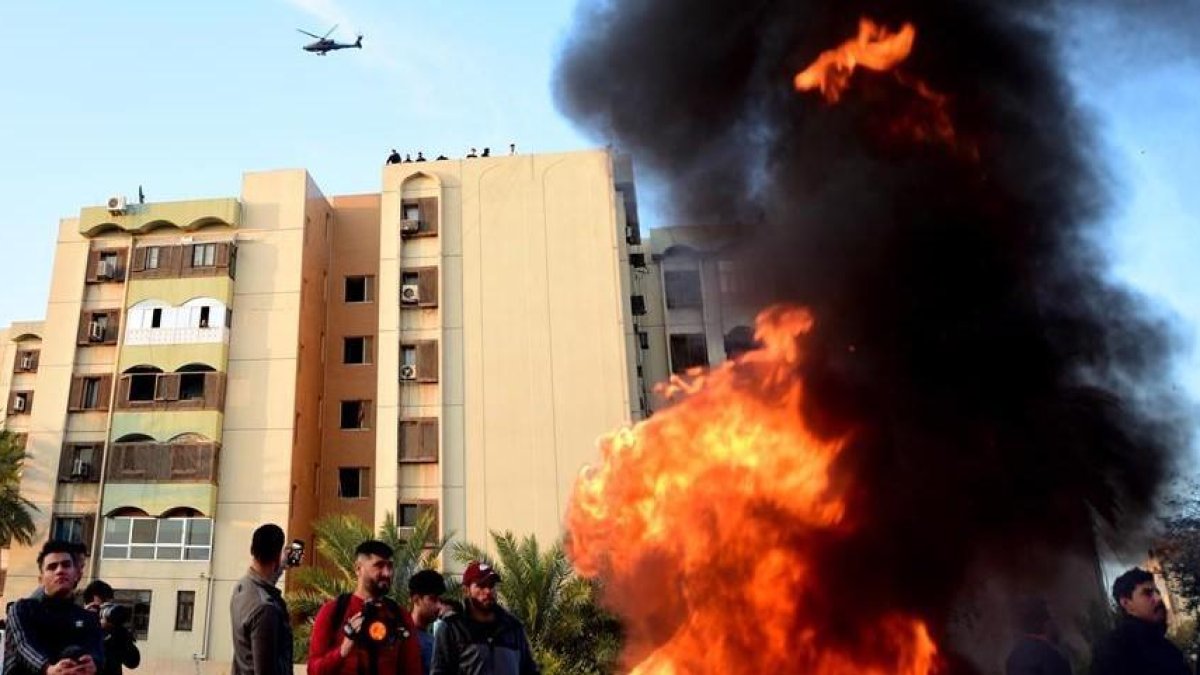 Un helicóptero estadounidense AH-64E Apache sobrevuela una manifestación de la agrupación armada iraquí Multitud Popular que se manifiestan en las inmediaciones de la embajada estadounidense en Bagdad, el miércoles 1 de enero.-EFE/ MURTAJA LATEEF