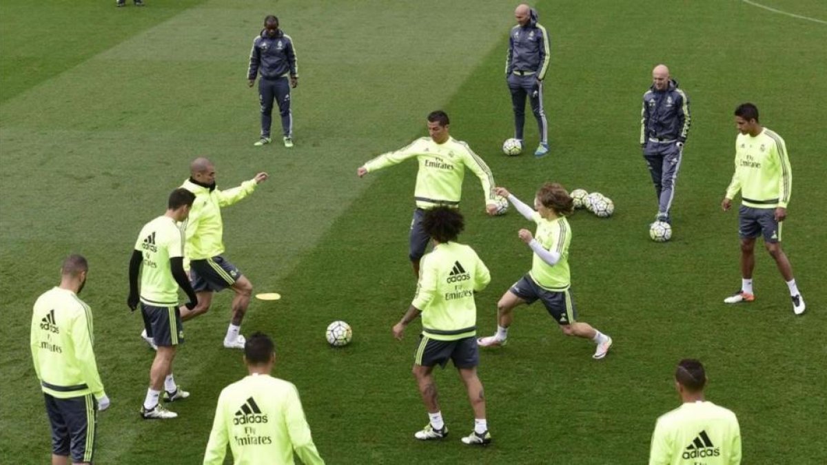 Zidane observa los movimientos de sus jugadores en el entrenamiento de este viernes en Valdebebas.-AFP / JAVIER SORIANO