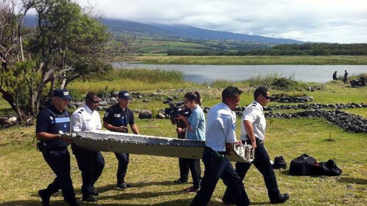 La Policía de las Islas Reunión traslada una de las piezas encontradas.-Foto: AFP