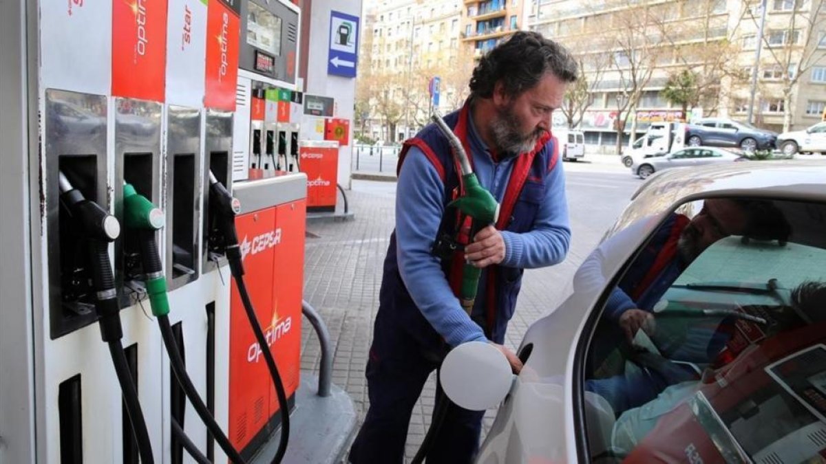 Un conductor reposta en una gasolinera de Barcelona.-EL PERIÓDICO