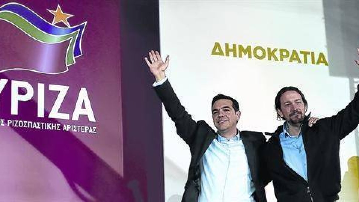 Tsipras, líder de Syriza, se abraza a Pablo Iglesias, su homólogo en Podemos, tras el mitin de ayer en la plaza Omonia de Atenas.-Foto:   AP / LEFTERIS PITARAKIS