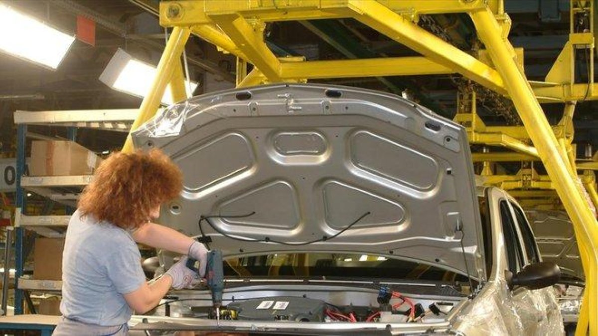 Una mujer, en la cadena de montaje de una fábrica de automóviles.-