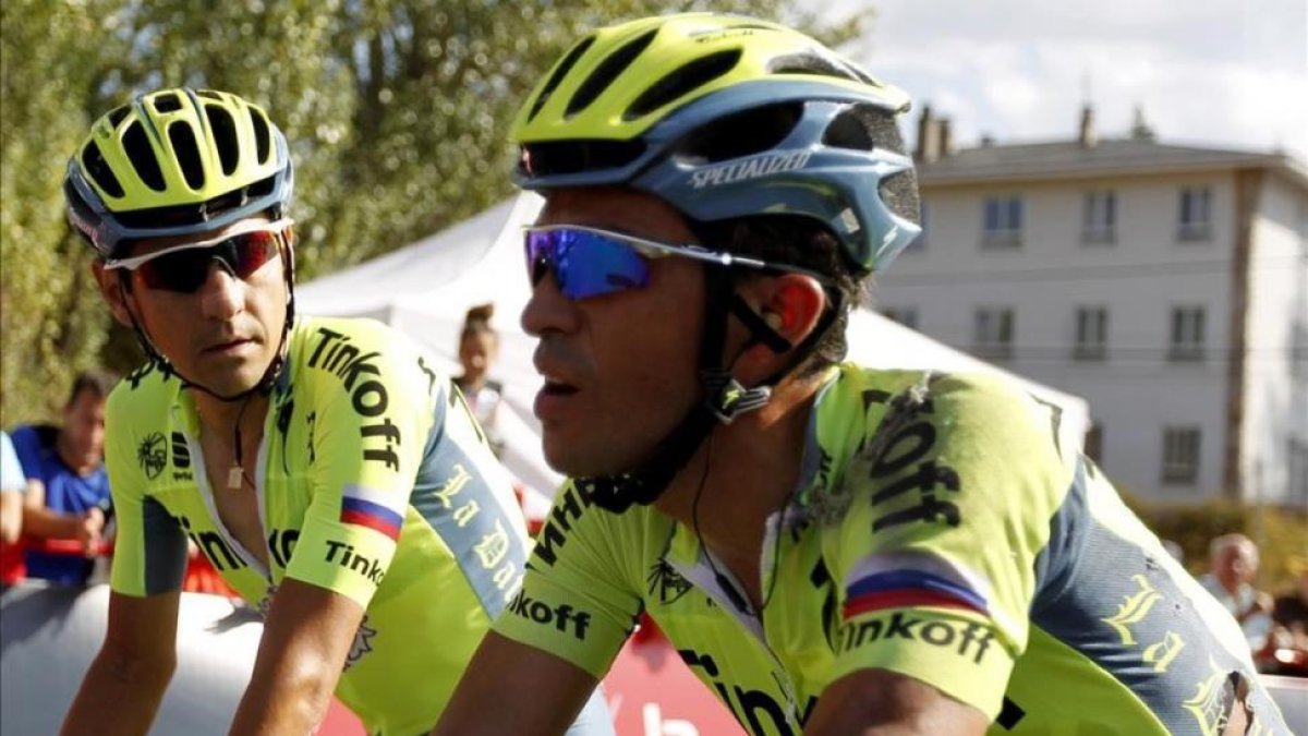 Alberto Contador cruza la meta de Puebla de Sanabria tras caer, acompañado por Jesús Hernández.-EFE / JAVIER LIZÓN