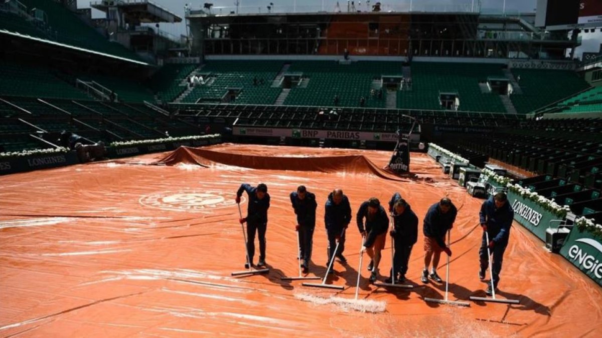 Operarios achican el agua en la central de Roland Garros.-CHRISTOPHE SIMON