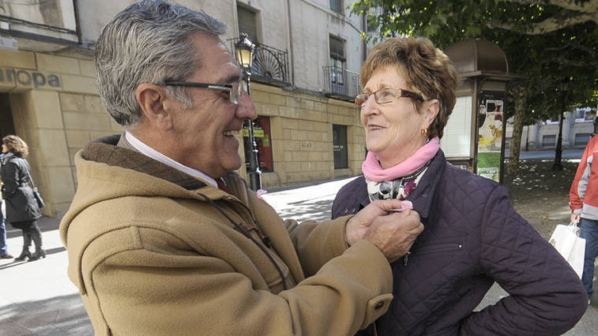 El presidente de la AECC coloca un lazo rosa. / Ú.S.-