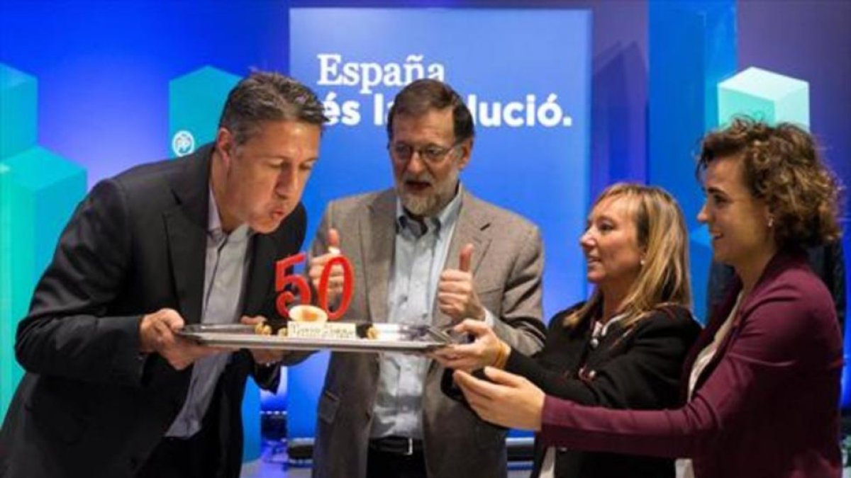 Garcia Albiol sopla las velas del pastel de su cumpleaños, en presencia de Mariano Rajoy, Marisa Xandri, líder del PP de Lleida, y Dolors Montserrat.-ACN